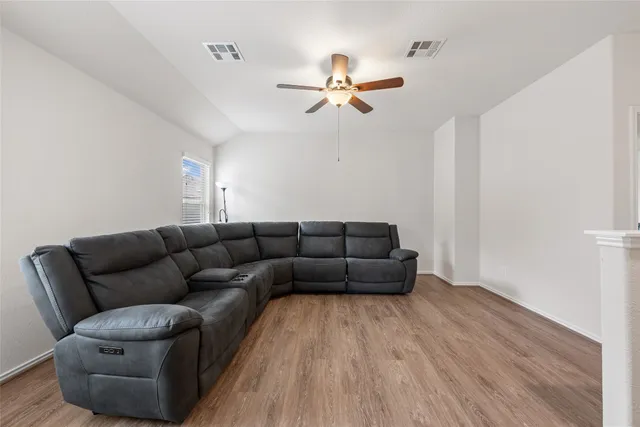 a living room with furniture and a wooden floor