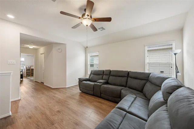 a living room with furniture and a ceiling fan