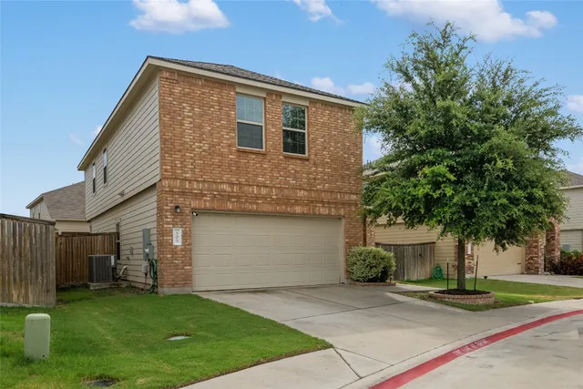 a front view of a house with a garden and yard