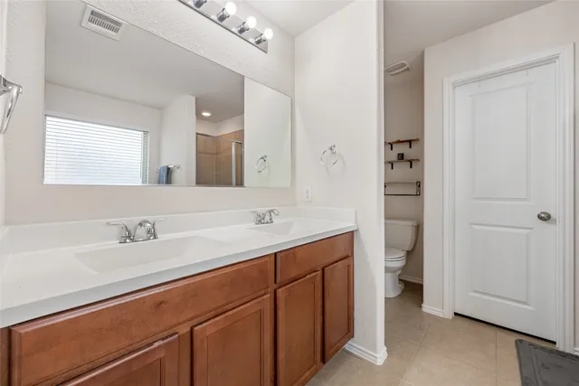 a bathroom with a sink a toilet and a large mirror