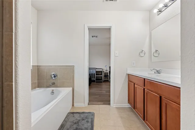 a bathroom with a tub sink and mirror