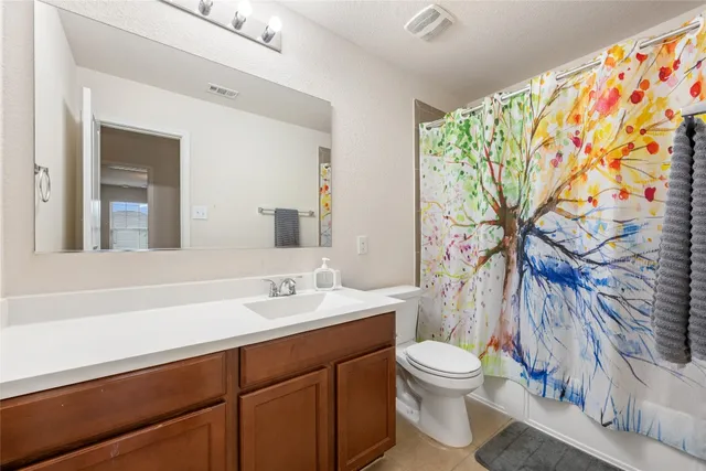 a bathroom with a granite countertop sink a toilet and a mirror