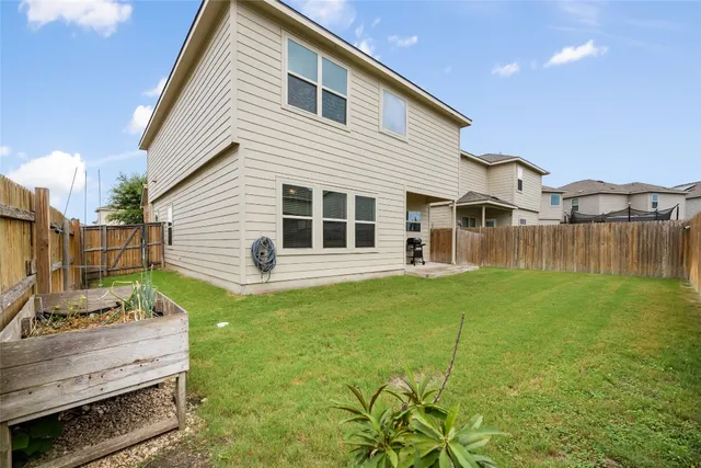 a backyard of a house with table and chairs