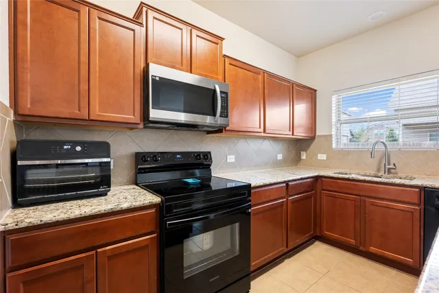 a kitchen with stainless steel appliances granite countertop a stove microwave and sink