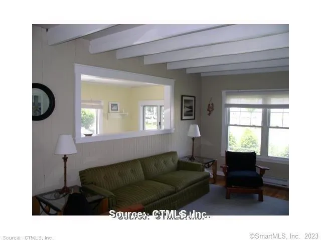 a living room with furniture a window and potted plants