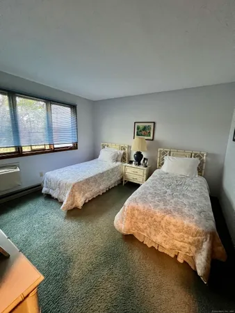 a spacious bedroom with two beds and window