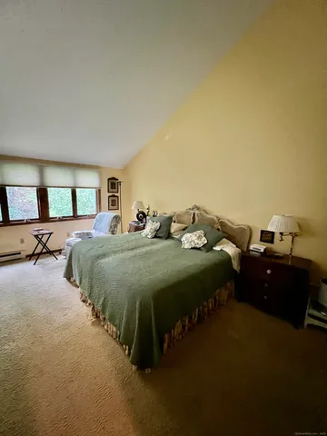 a spacious bedroom with a bed and wooden floor
