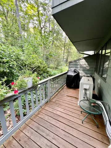 a view of roof deck with wooden floor and seating space
