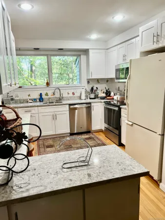 a kitchen with a sink a stove and chairs