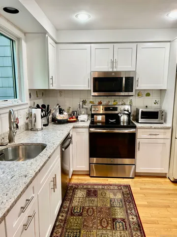 a kitchen with stainless steel appliances granite countertop a sink and a stove