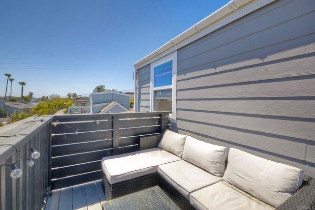 a balcony with wooden floor table and chairs