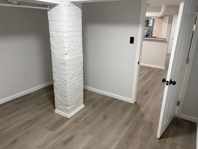 an empty room with wooden floor and white walls