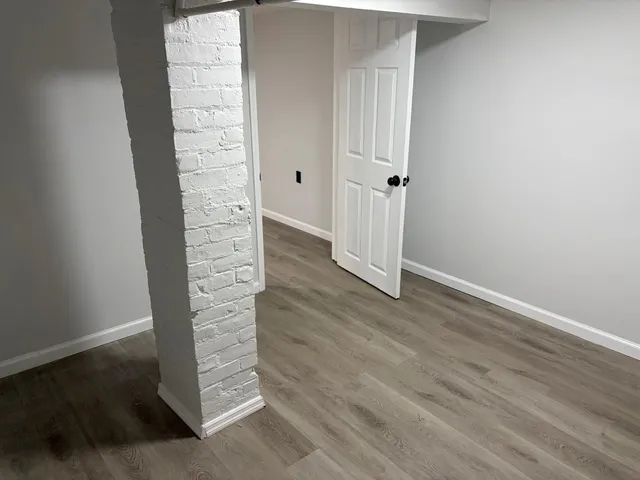 an empty room with wooden floor and closet