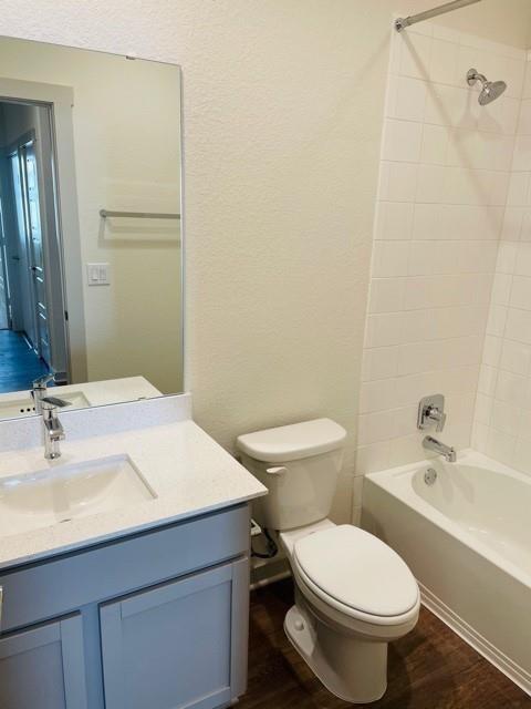 161 Filifera Court Leander, TX 78641 - Photo 11 of 13 Full bathroom with toilet, wood finished floors, shower combination, and vanity