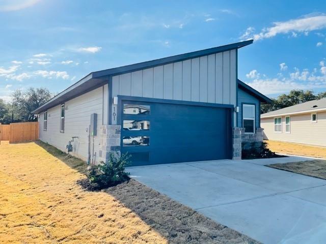 161 Filifera Court Leander, TX 78641 - Photo 2 of 13 View of property exterior featuring board and batten siding, stone siding, driveway, and fence