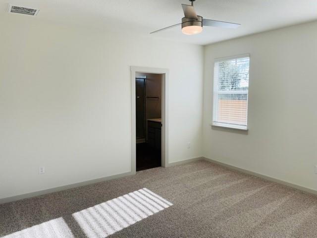 161 Filifera Court Leander, TX 78641 - Photo 7 of 13 Unfurnished bedroom featuring light colored carpet, baseboards, and ceiling fan