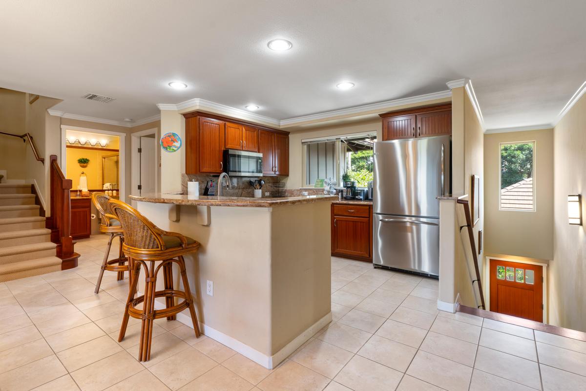 68-1122 Na Ala Hele Road, Unit H22 Kamuela, HI 96743 - Photo 6 of 30 a kitchen with stainless steel appliances a refrigerator and a stove top oven