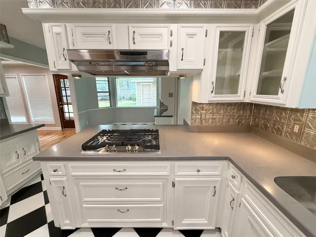 a kitchen with a checkered floor and white cabinets