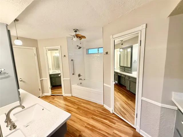 a spacious bathroom with a granite countertop sink double vanity and a mirror