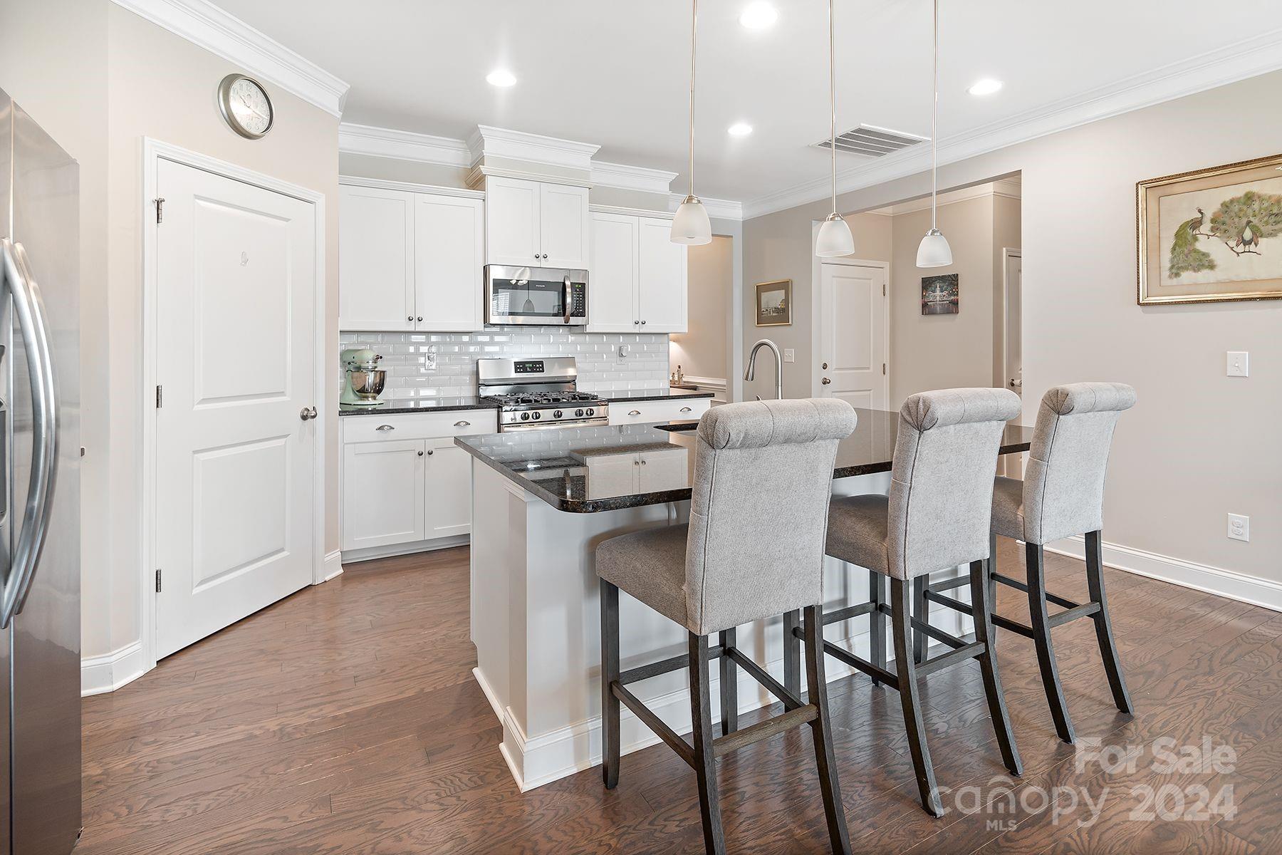 118 East Northstone Road Mooresville, NC 28115 - Photo 5 of 33 a kitchen with stainless steel appliances kitchen island granite countertop a table chairs and a refrigerator
