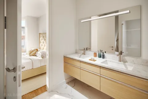 a en suite bathroom with a double vanity sink and mirror