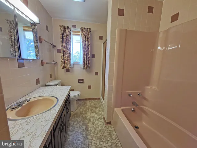 a bathroom with a tub sink and mirror