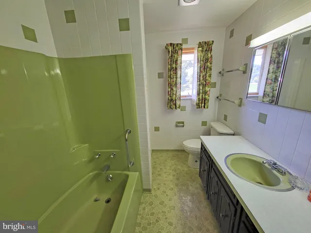 a spacious bathroom with a granite countertop sink a toilet and shower