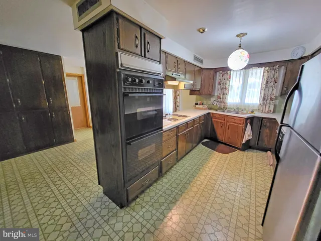 a kitchen with stainless steel appliances granite countertop a sink a stove and a refrigerator