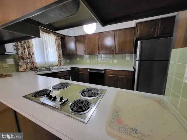 a kitchen with a stove a refrigerator and a sink
