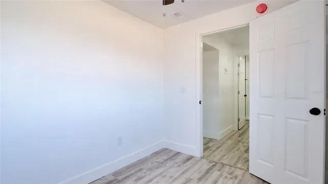 a view of a hallway with wooden floor and closet