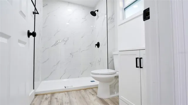a bathroom with a toilet a sink and shower