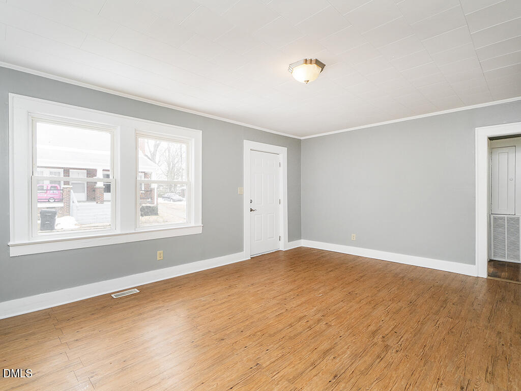 133 Brooks Street Burlington, NC 27215 - Photo 3 of 24 an empty room with wooden floor and windows