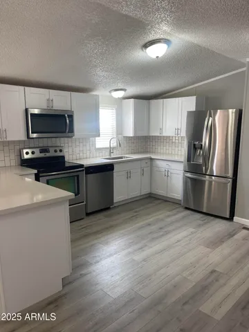 a kitchen with appliances a sink and a refrigerator