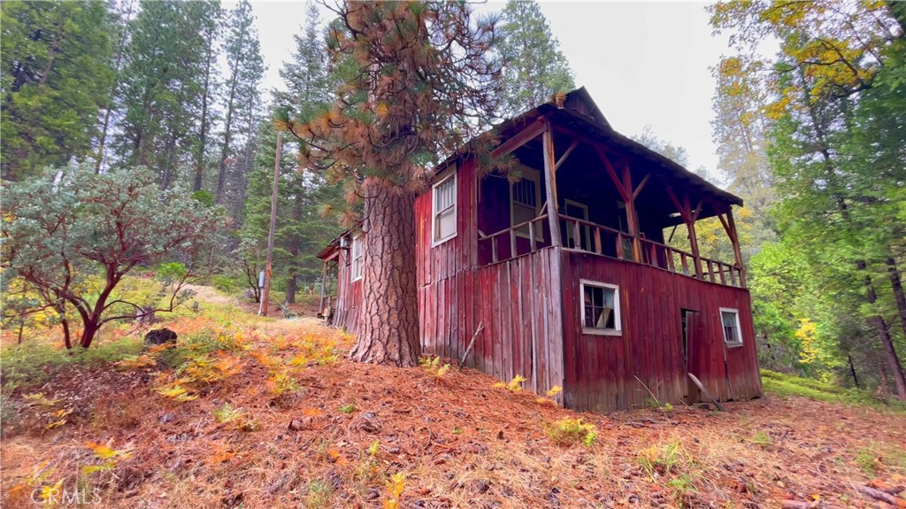 6180 Chowchilla Mountain Road Mariposa, CA 95338 - Photo 5 of 11 a view of a wooden house with a yard