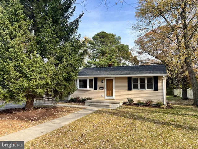 a front view of a house with a yard and trees