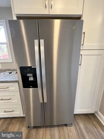 a view of water heater room with wooden floor
