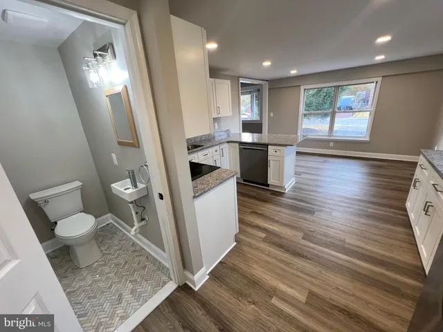 a bathroom with a sink a toilet a window and vanity
