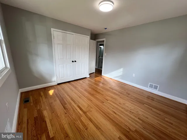 a view of an empty room with wooden floor