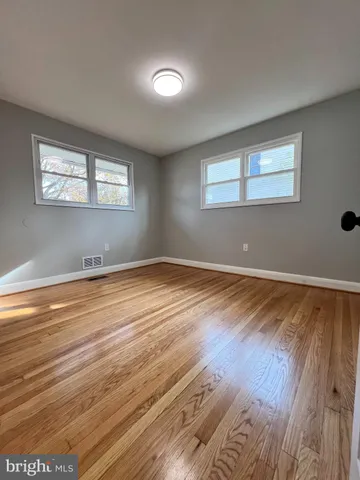a view of room with wooden floor and windows