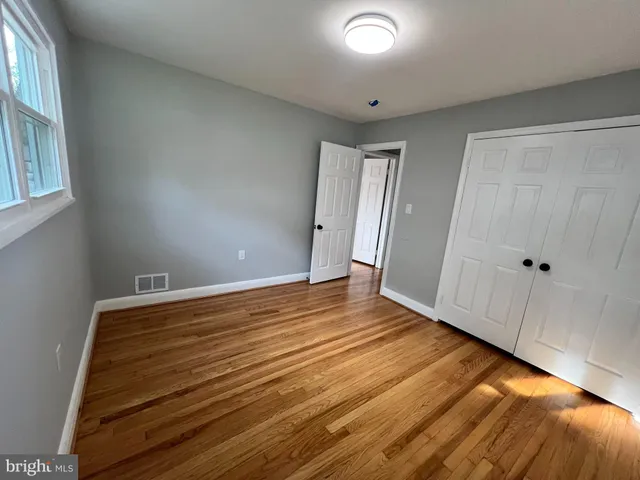 a view of empty room with wooden floor