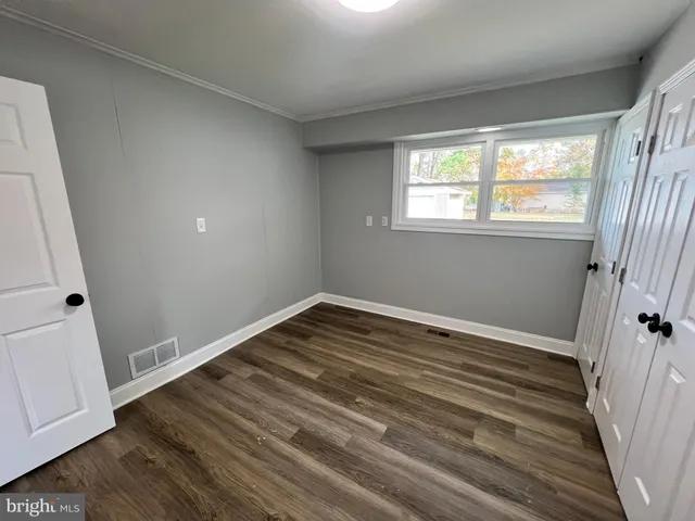 a view of a room with wooden floor and window