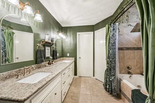 a bathroom with a granite countertop double vanity sink and a mirror
