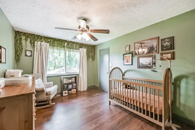 a bedroom with furniture wooden floor and a window