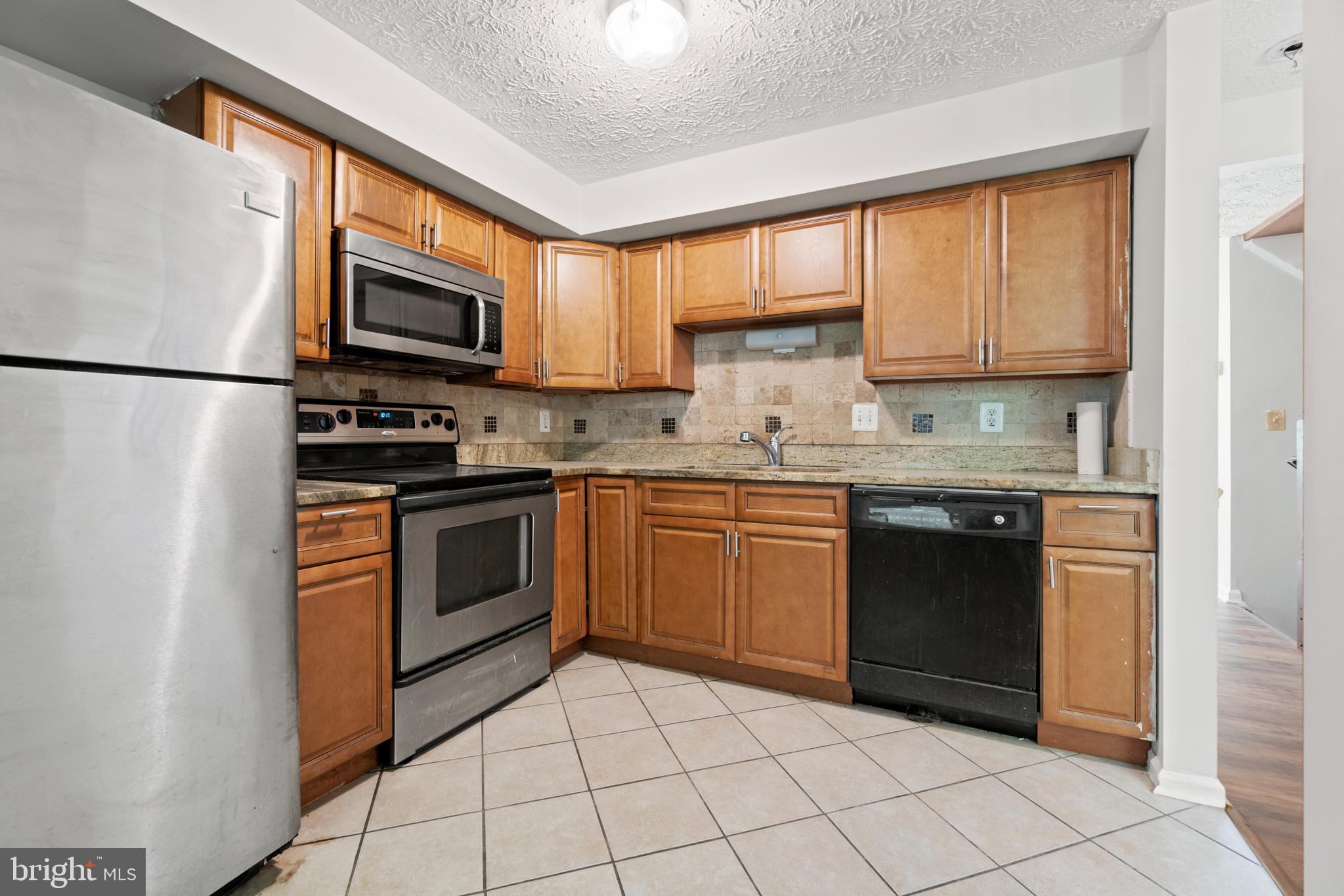 3618 Wharf Lane Triangle, VA 22172 - Photo 11 of 27 a kitchen with stainless steel appliances granite countertop a refrigerator sink and stove