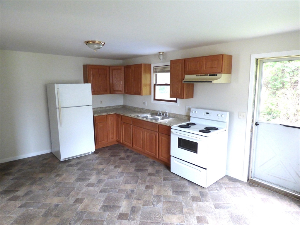 26-28 Daniel Street Springfield, MA 01151 - Photo 4 of 15 a kitchen with a stove a sink and a refrigerator