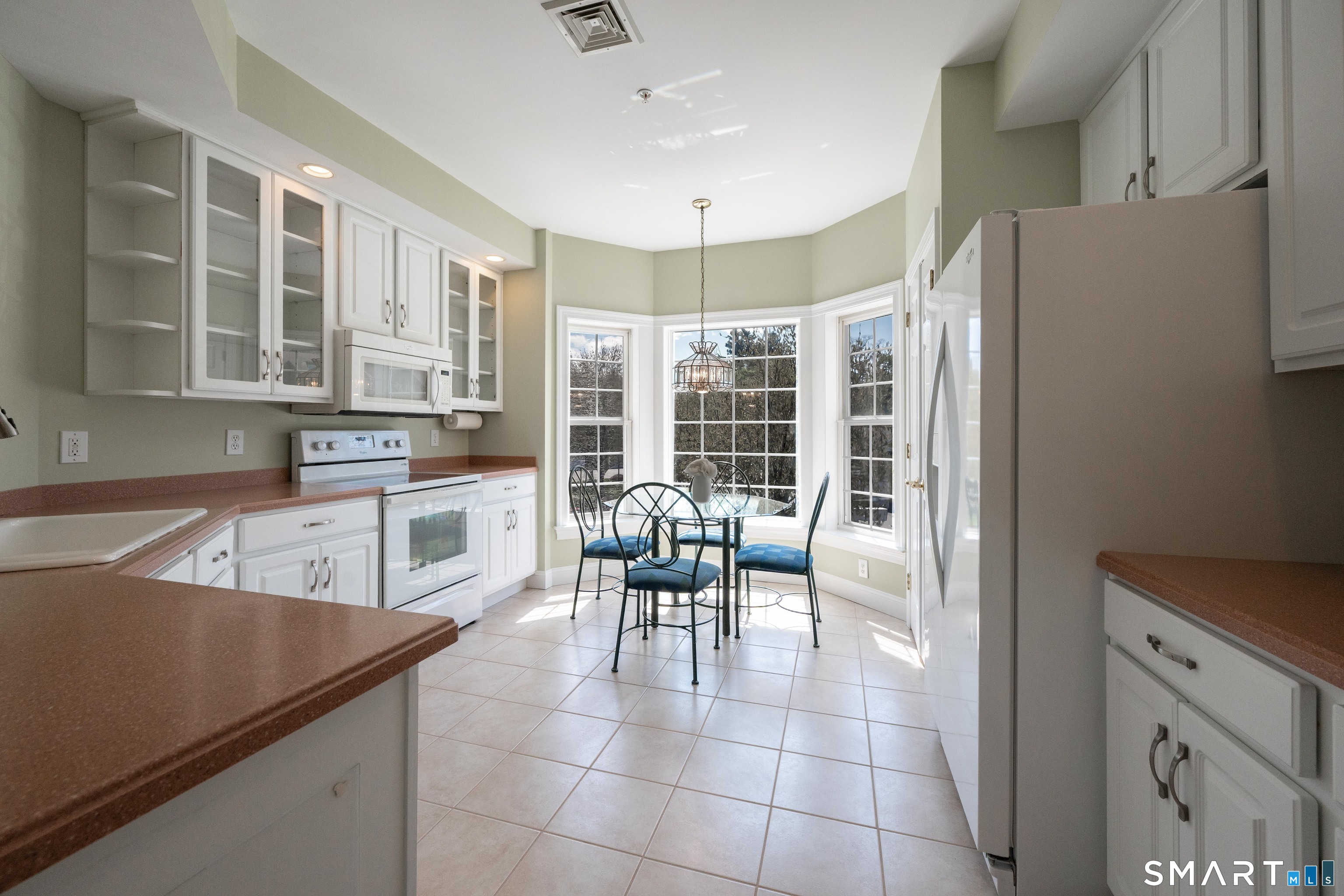 10 Hayestown Road, Unit 321 Danbury, CT 06811 - Photo 16 of 39 a kitchen with granite countertop a refrigerator a stove a dining table and chairs