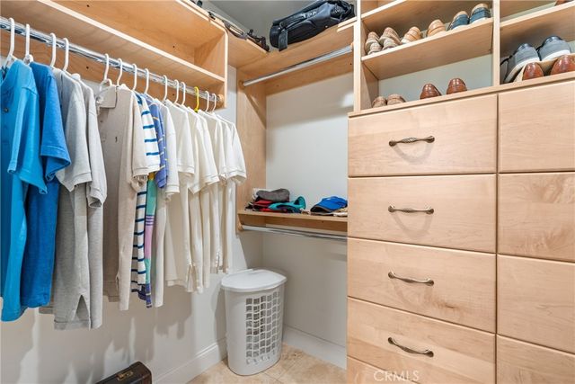 a view of walk in closet with clothes and shoes