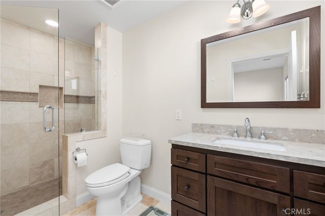 a bathroom with a toilet sink vanity and shower