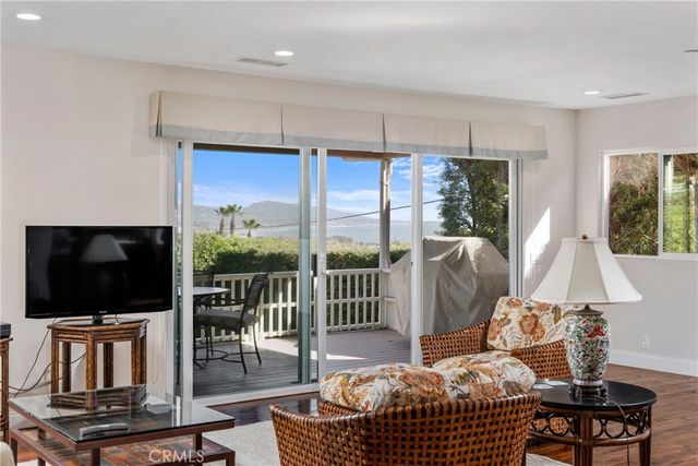 a living room with furniture tv and floor to ceiling window