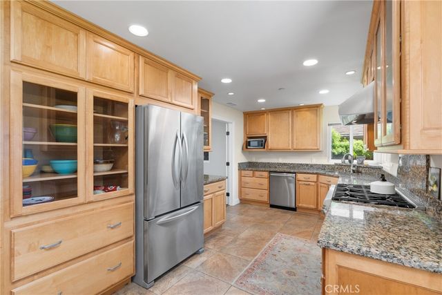 a kitchen with stainless steel appliances granite countertop a refrigerator and a stove